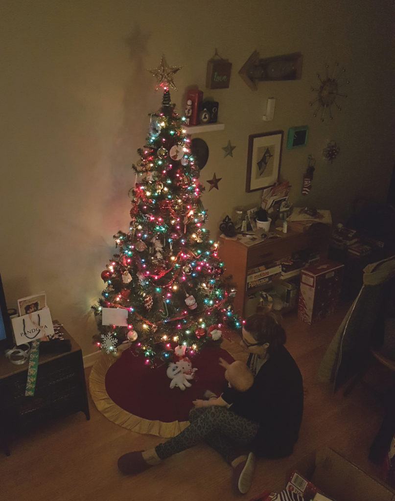 mom and baby sitting in front of Christmas tree