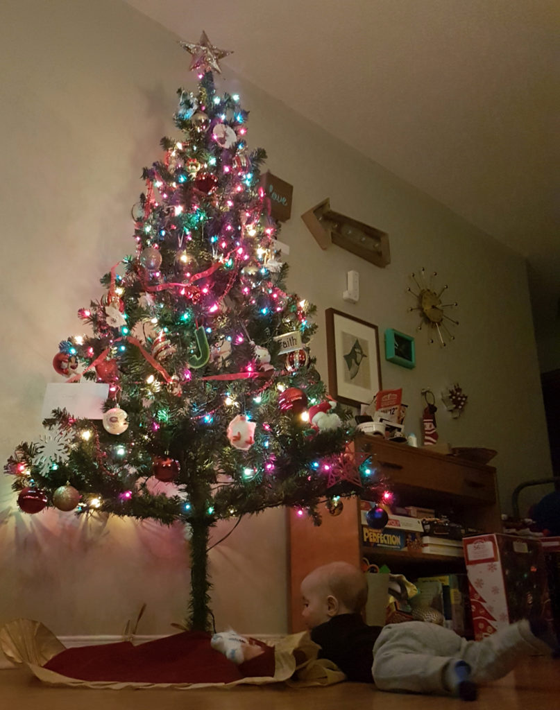 baby in front of Christmas tree